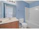 Blue bathroom features a single sink vanity, mirror, and shower-tub combo at 810 Bibury Ct, Charleston, SC 29414