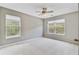 Neutral bedroom featuring a ceiling fan and two bright windows at 810 Bibury Ct, Charleston, SC 29414
