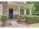 Inviting front porch with stone accents, manicured bushes, and a stylish black front door at 810 Bibury Ct, Charleston, SC 29414