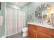 Bathroom with a wooden vanity and framed, round mirror at 8327 Childs Cove Cir, North Charleston, SC 29418