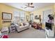 Well-lit bedroom featuring bright yellow walls, ceiling fan, and a cozy seating area at 8327 Childs Cove Cir, North Charleston, SC 29418