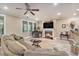 Cozy living room featuring a fireplace, ceiling fan, and a window view of lush greenery at 8327 Childs Cove Cir, North Charleston, SC 29418