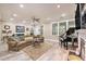 Cozy living room featuring a fireplace, ceiling fan, and a window view of lush greenery at 8327 Childs Cove Cir, North Charleston, SC 29418