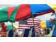 A vibrant beach scene with colorful umbrellas and an American flag creating a festive atmosphere at 837 Club Cottage Rd, Edisto Island, SC 29438