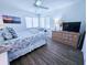Bright bedroom with coastal-themed bedding, a ceiling fan, and plenty of natural light from the large window at 837 Club Cottage Rd, Edisto Island, SC 29438