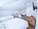 Bright bedroom features multiple beds, a sofa, and a wicker trunk for storage at 837 Club Cottage Rd, Edisto Island, SC 29438