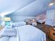 Bright bedroom featuring multiple beds, cozy seating area, and stylish decor under vaulted ceiling at 837 Club Cottage Rd, Edisto Island, SC 29438