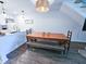 Bright dining area with a rustic wooden table, bench, and a view of the modern kitchen featuring white cabinets at 837 Club Cottage Rd, Edisto Island, SC 29438