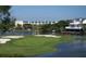 Beautiful waterfront golf course featuring a green, sand trap, and building in the distance at 837 Club Cottage Rd, Edisto Island, SC 29438