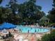 Community pool with people relaxing and enjoying the sunny weather amidst lush greenery at 837 Club Cottage Rd, Edisto Island, SC 29438