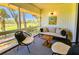 Comfortable screened porch with golf course views, cozy seating, and bright natural light at 837 Club Cottage Rd, Edisto Island, SC 29438