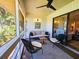 Relaxing screened porch with ceiling fan, comfortable seating, and outdoor view at 837 Club Cottage Rd, Edisto Island, SC 29438