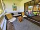 Cozy screened-in porch with comfortable seating and views of a lush green landscape at 837 Club Cottage Rd, Edisto Island, SC 29438