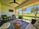 Relaxing screened porch with TV, seating, golf course views, and bright natural light at 837 Club Cottage Rd, Edisto Island, SC 29438