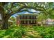 Expansive two-story home featuring a double balcony nestled beneath a majestic, mature tree canopy at 88 Smith St, Charleston, SC 29401
