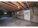 Unfinished basement with exposed ceiling joists, a concrete floor, and a white door at 88 Smith St, Charleston, SC 29401