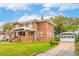 Charming two-story brick home featuring a manicured lawn and a detached garage with a pergola-covered walkway at 88 Smith St, Charleston, SC 29401