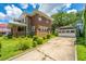 Charming two-story brick home featuring a lush green lawn and a detached garage with a pergola-covered walkway at 88 Smith St, Charleston, SC 29401