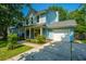 Charming two-story home with a welcoming front porch, attached garage, landscaped yard, and inviting curb appeal at 103 Toura Ln, Charleston, SC 29414