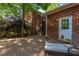 A patio with brick facade, lush trees, and outdoor seating presents a charming backyard at 105 Birkbeck Ct, Goose Creek, SC 29445