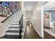 Bright hallway featuring hardwood floors, staircase with Gathering photos, and views into adjacent rooms at 105 Birkbeck Ct, Goose Creek, SC 29445