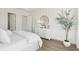 Bright bedroom with white dresser, round mirror, and neutral wallpaper at 109 Orchard Blossom Ln, Summerville, SC 29485