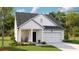 Charming single-Gathering home with a cozy front porch and attached garage, surrounded by lush greenery at 111 Pen Shell St, Summerville, SC 29485