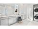 A pristine bathroom features double sinks, vanity and seating area, and stacked washer dryer at 114 Battle Boat Blvd, Summerville, SC 29485