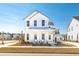 Charming two-story white home featuring a covered porch and beautifully landscaped front yard at 114 Battle Boat Blvd, Summerville, SC 29485
