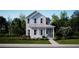 Inviting two-story home with a charming covered porch, set amidst lush greenery and mature trees at 114 Battle Boat Blvd, Summerville, SC 29485
