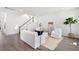 Bright living room with hardwood floors, white sofas, a staircase, and a decorative potted plant at 114 Battle Boat Blvd, Summerville, SC 29485