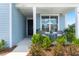 Inviting front porch featuring charming chairs, plants, and tasteful landscaping around the home at 123 Leeward Lndg, Summerville, SC 29486