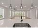 Bright kitchen featuring a black faucet over a white countertop and lights in the living room at 123 Leeward Lndg, Summerville, SC 29486