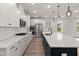 Modern kitchen features white cabinets, stainless steel appliances, a large island, and hardwood floors at 123 Leeward Lndg, Summerville, SC 29486