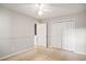 A beige carpeted bedroom with white trim, a ceiling fan, closet, and an open door at 133 Guildford Dr, Goose Creek, SC 29445