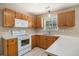 Functional kitchen with wood cabinets, white appliances, and tile flooring at 133 Guildford Dr, Goose Creek, SC 29445