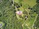 Aerial shot features a home nestled among lush trees, with a pool, and extensive land in a private setting at 138 Brant Acres Ln, Bonneau, SC 29431