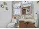 Quaint powder room featuring a vanity with gold hardware, decorative mirrors, and wallpaper at 138 Brant Acres Ln, Bonneau, SC 29431