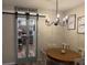 Charming dining room showcases chandelier, framed prints, and barn door to pantry at 138 Brant Acres Ln, Bonneau, SC 29431