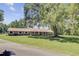 Brick house with a metal roof, a covered porch, and a big tree in a manicured lawn at 138 Brant Acres Ln, Bonneau, SC 29431