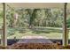 View from the porch shows a large front yard with mature trees and green grass, framed by white porch columns at 138 Brant Acres Ln, Bonneau, SC 29431