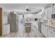 Spacious kitchen with white cabinets, stainless steel appliances, a center island, and modern wood look flooring at 138 Brant Acres Ln, Bonneau, SC 29431