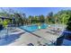 A community pool surrounded by palm trees, lounge chairs, and landscaping on a sunny day at 1604 Basildon Rd, Mount Pleasant, SC 29466