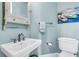 Charming powder room with pedestal sink, decorative mirror, and blue wall paint at 1636 Rivertowne Country Club Dr, Mount Pleasant, SC 29466
