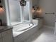 Bright bathroom features a marble-tiled tub and vanity, along with updated lighting fixtures at 1636 Rivertowne Country Club Dr, Mount Pleasant, SC 29466
