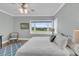 A well-lit bedroom features a plush rug, hardwood floors, a ceiling fan, and large windows with golf course views at 1636 Rivertowne Country Club Dr, Mount Pleasant, SC 29466