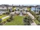 Elegant two-story home featuring a well-manicured lawn, mature palms, and a classic exterior at 1636 Rivertowne Country Club Dr, Mount Pleasant, SC 29466