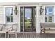 Charming front door with glass windows, flanked by classic lanterns and wooden benches, creating a welcoming entrance at 1636 Rivertowne Country Club Dr, Mount Pleasant, SC 29466