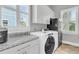 Modern laundry room with appliances, cabinets, and granite countertops at 1636 Rivertowne Country Club Dr, Mount Pleasant, SC 29466
