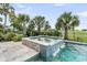 Beautiful backyard pool with a spa featuring a waterfall, surrounded by lush landscaping and palm trees at 1636 Rivertowne Country Club Dr, Mount Pleasant, SC 29466
